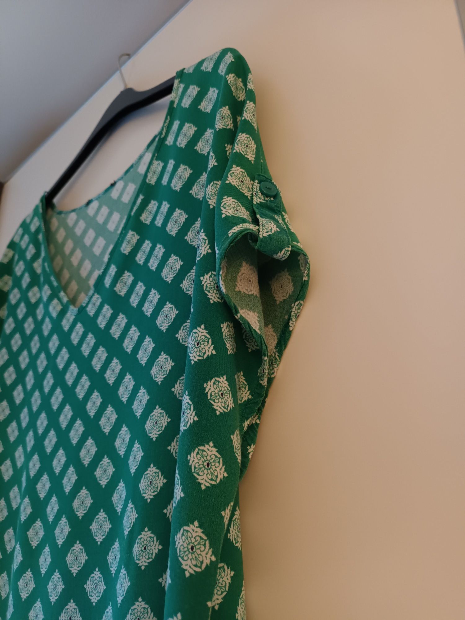 Blusa verde com padrão de flores brancas