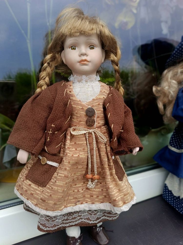 Porcelanowa lalka w brązowej sukience