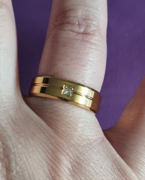 Anel/aliança dourado, em aço inoxidável, com 1 brilhante. T17