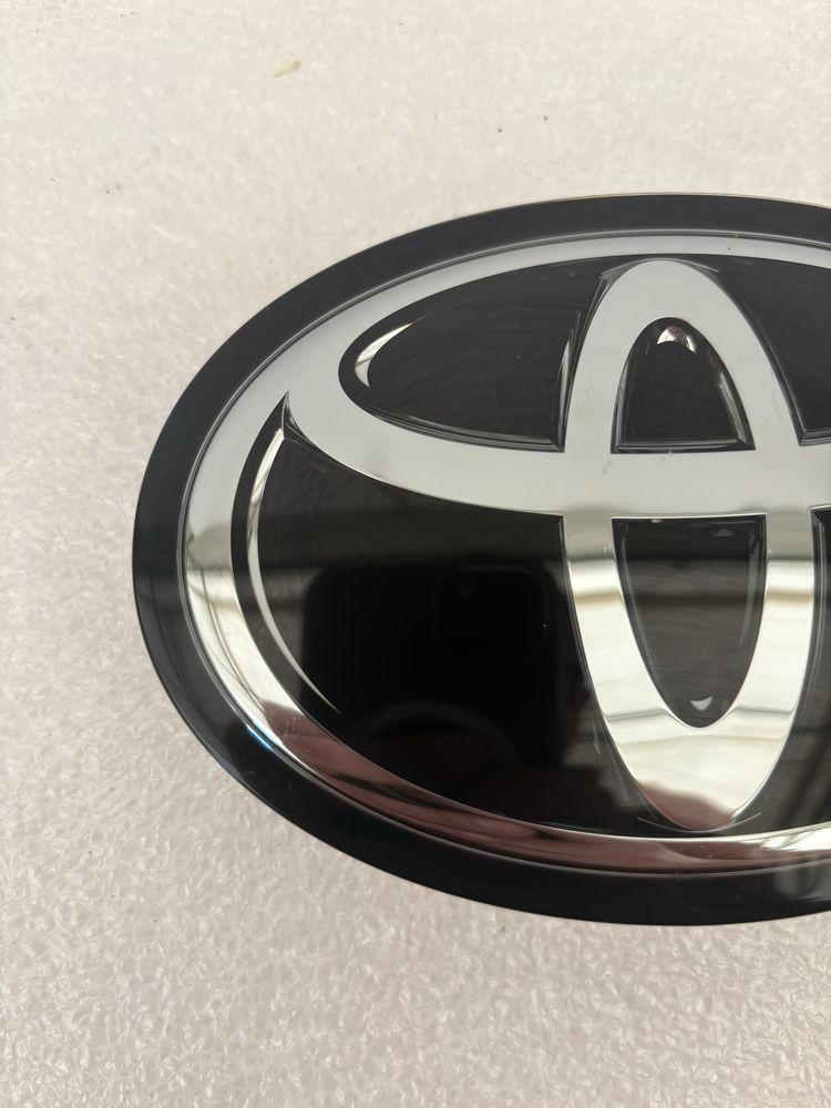 Toyota Corolla E21 sedan emblemat znaczek logo przód pod radar grilla