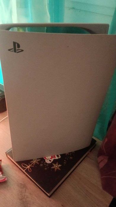 Консоль PlayStation 5 и несколько дисков с четверки