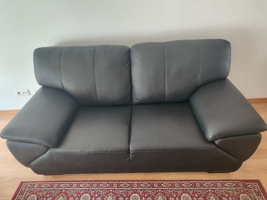 Vendo um sofá de dois lugares em pele preta.