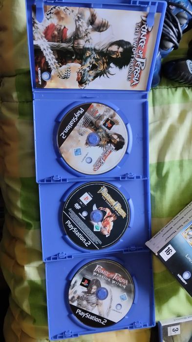 PlayStation 2 com dois jogos clássicos e dois comandos