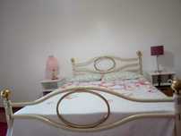 Cama em metal com detalhes dourados
