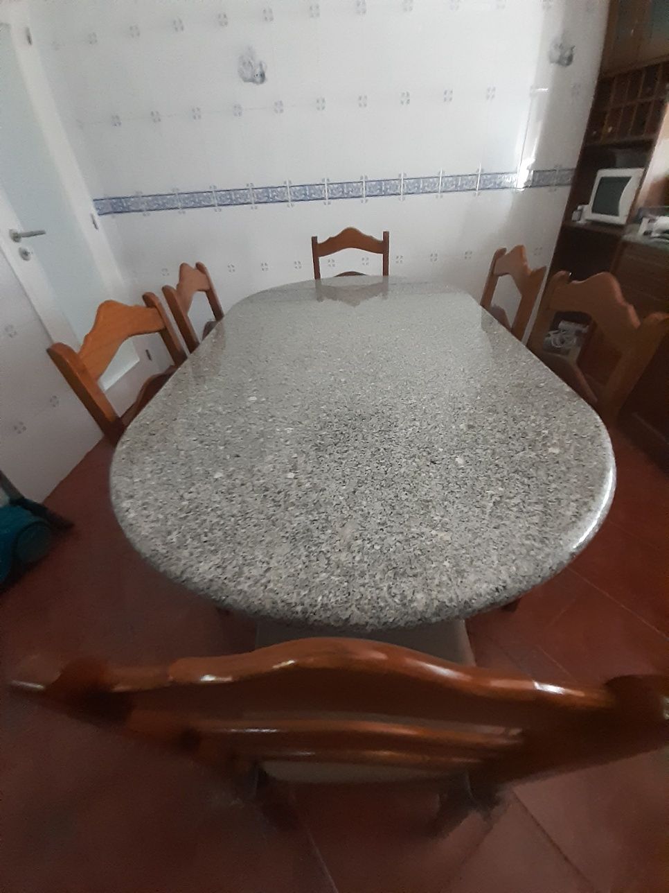 Mesa de pedra com 6 cadeiras.