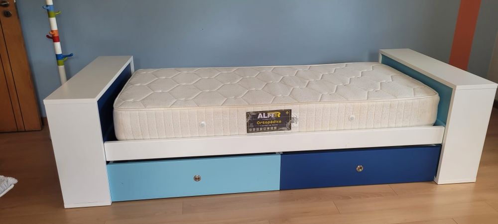Cama com gavetões, colchão e cabide. Cores em tons de azul.