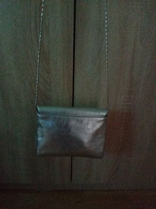 Torebka damska koloru srebrnego z z dłuszym paskiem srebrnym.