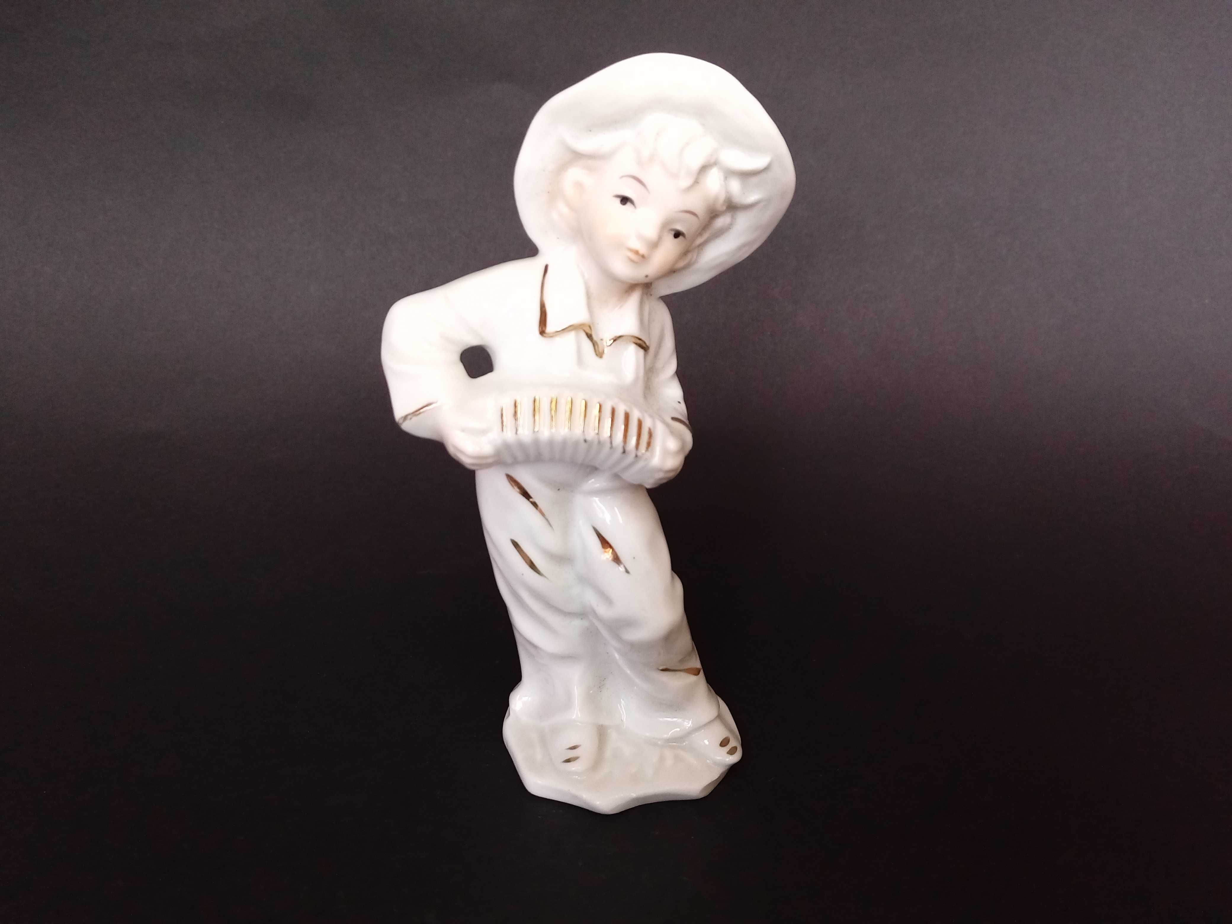 Ceramiczna figurka chłopiec z harmonią