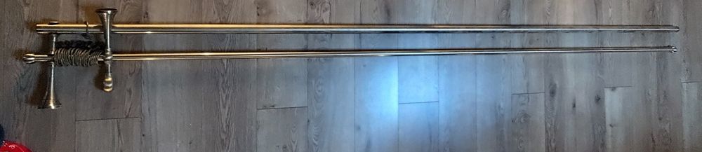 Karnisz z dwoma rurkami używany w złotym kolorze.