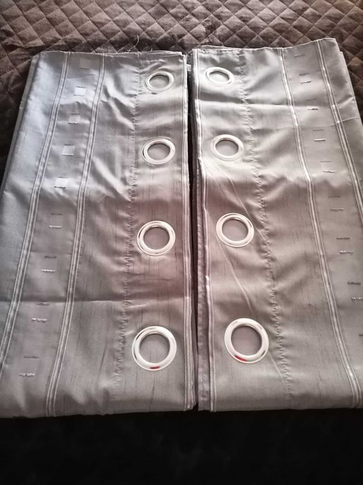 Cortinados acetinados e duas almofadas decorativas.