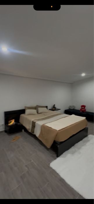 cama de casal com uma mesinha de cabeceira