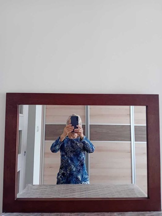 Lustro z brązową ramką.