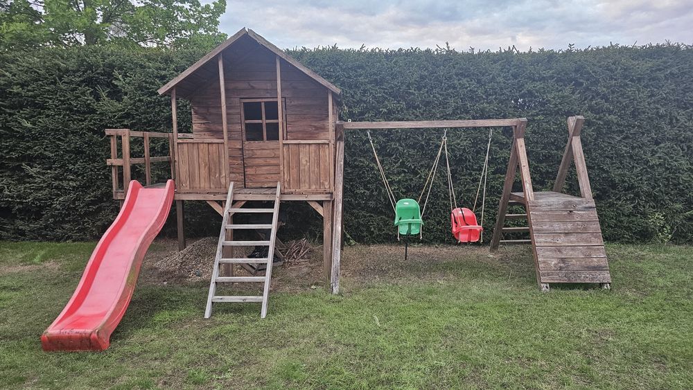 Domek dla dzieci z tarasem zjeżdżalnią huśtawkami  ścianką wspinaczkow
