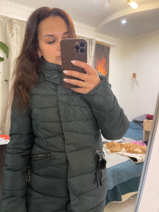 Теплий пуховик зеленого кольору.