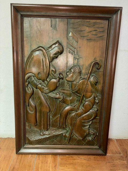 Escultura em relevo em madeira que representa uma cena religiosa.