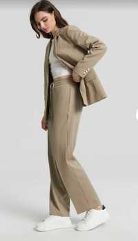 Базові  брюки палаццо тепло-оливкового кольору тренд сезону