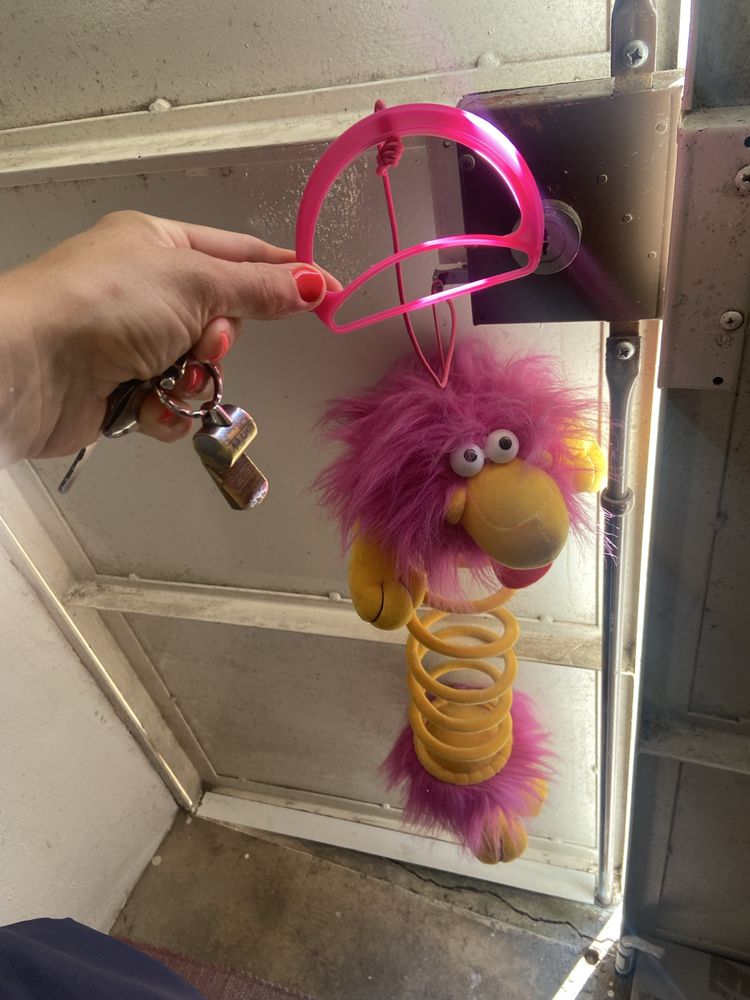 Boneco em peluche com mola e pega para pendurar