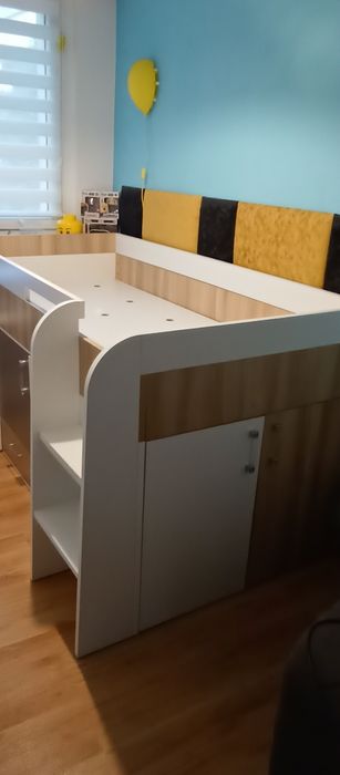 Łóżko dziecięce z szafką, szufladami, półkami i biurkiem.