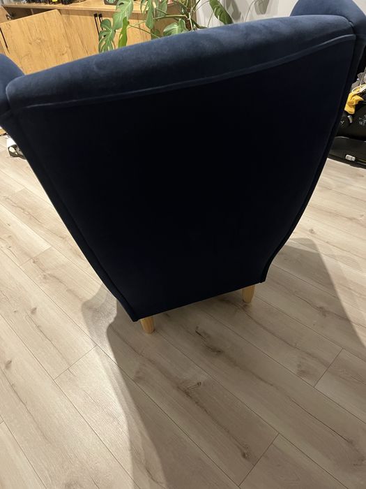 Granatowy fotel welurowy typu uszak