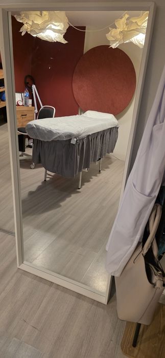 Espelho grande com moldura branca.