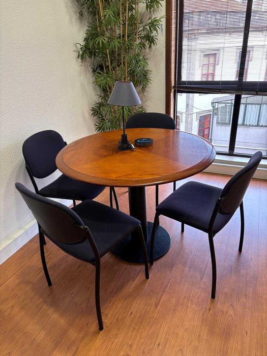 Mesa com 4 cadeiras e secretária de escritório.