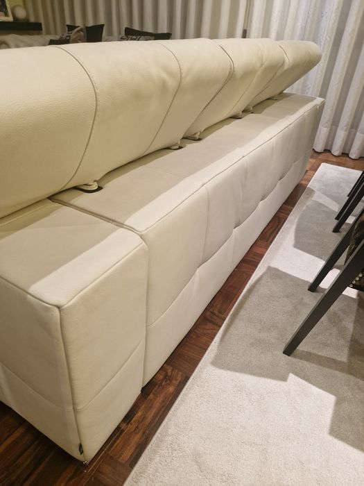 Sofá três lugares em pele beje.