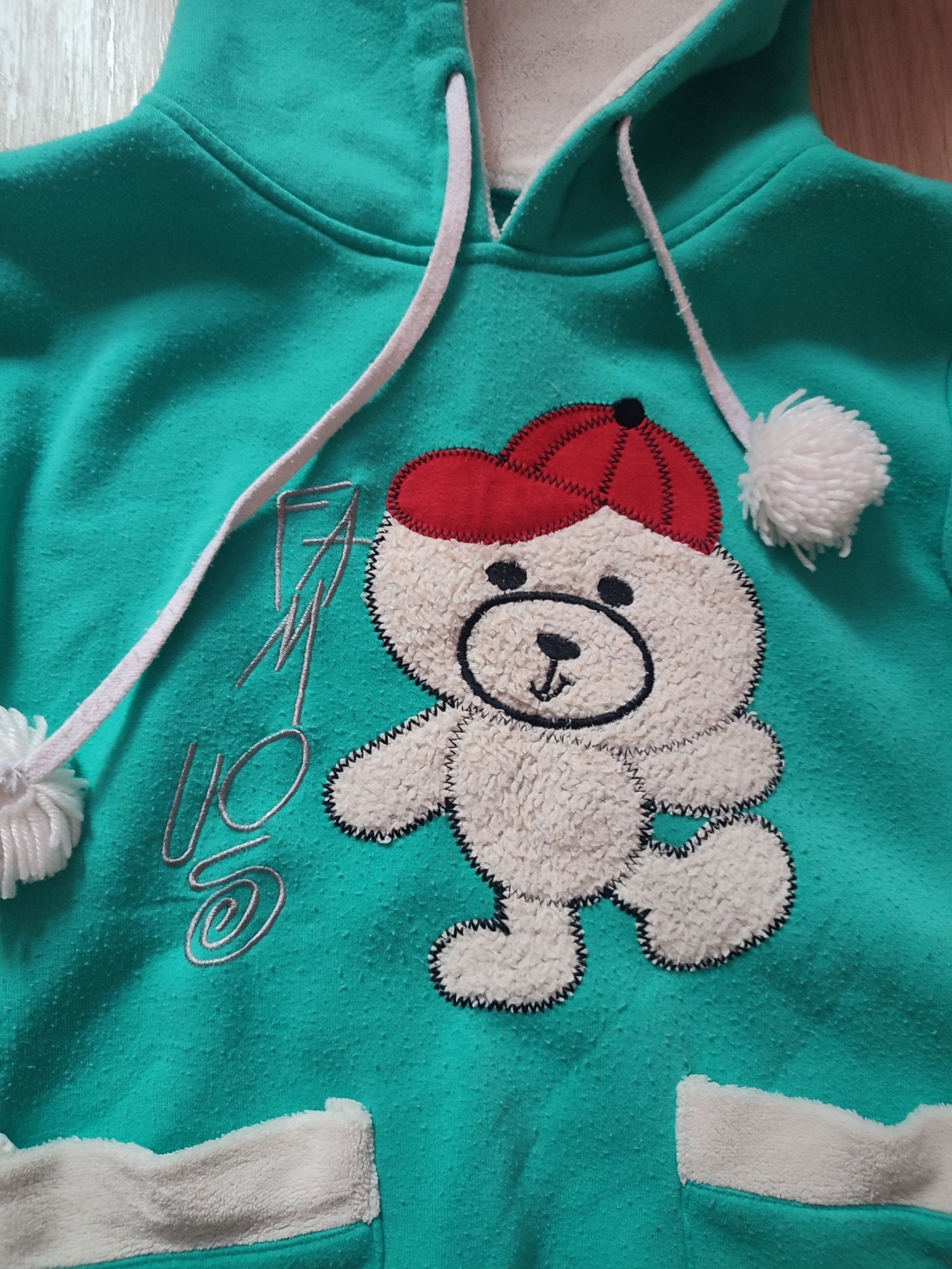 Zielona bluza sweter z kapturem i pomponami miś