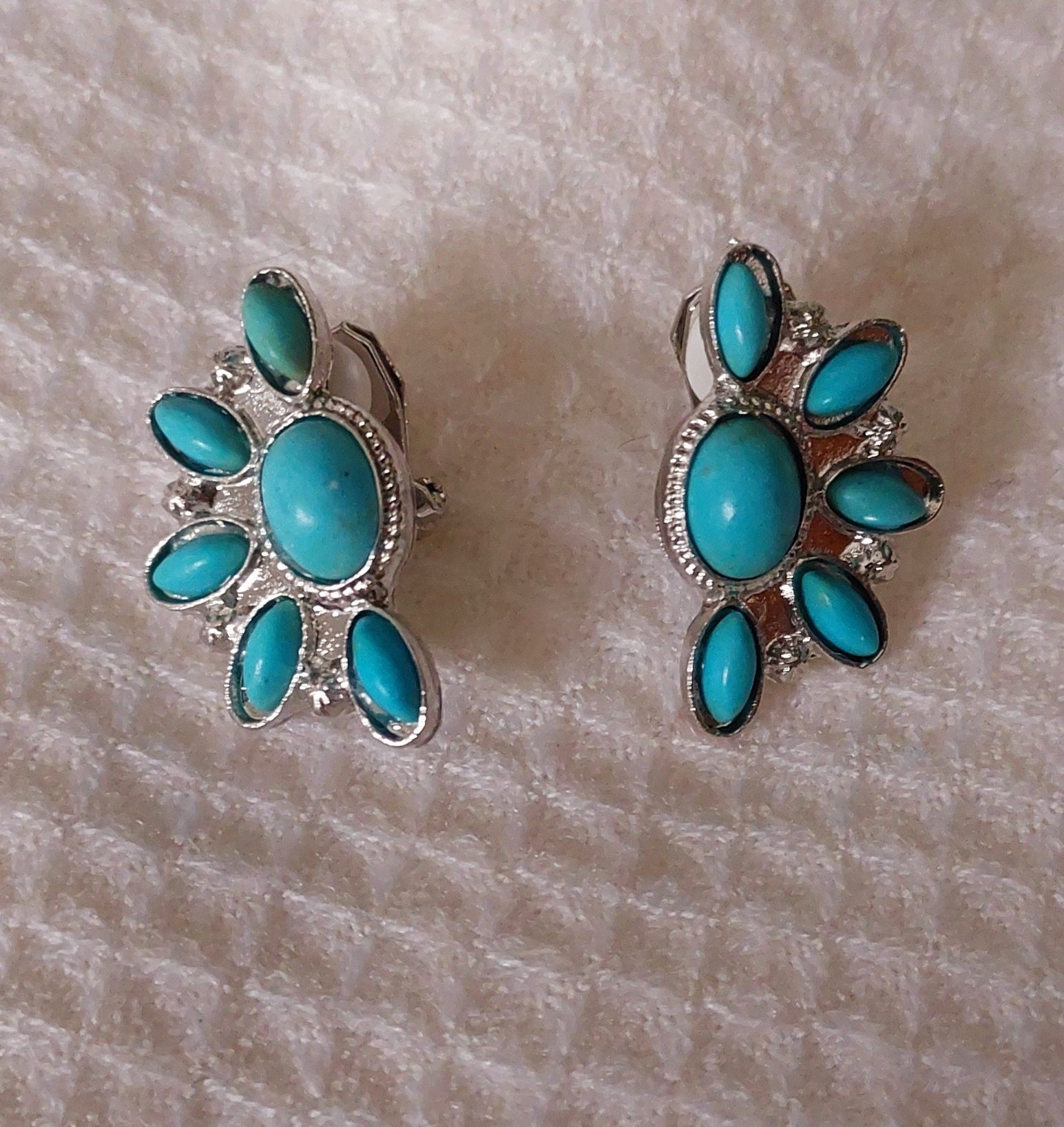 Brincos de metal de mola, com peças azuis.