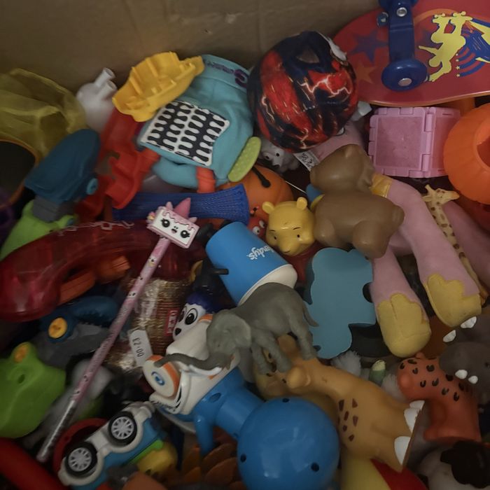 На изображении показана коробка, наполненная разнообразными игрушками.