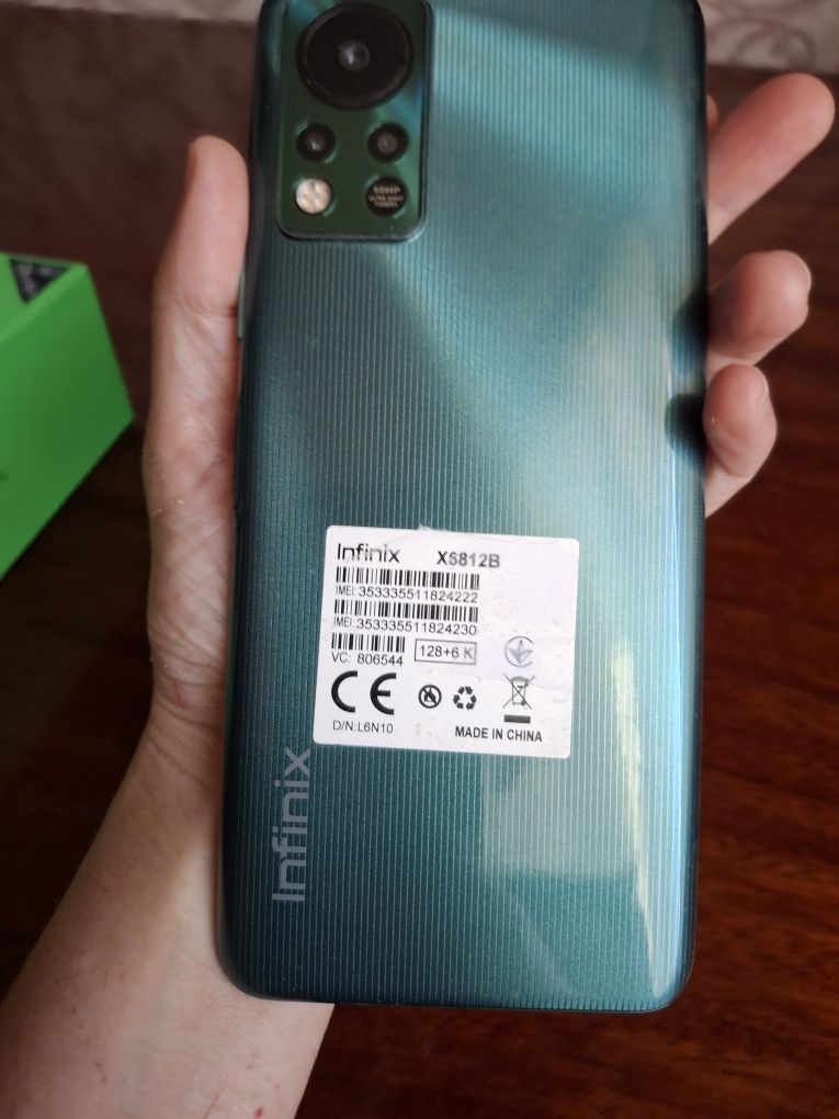 Телефон Infinix з зарядним устройсвом.
