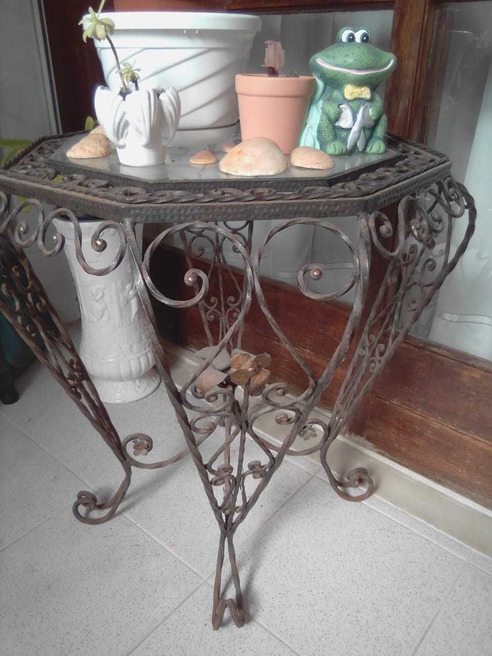 mesa de decoração antiga feita em ferro trabalhado com tampa de vidro