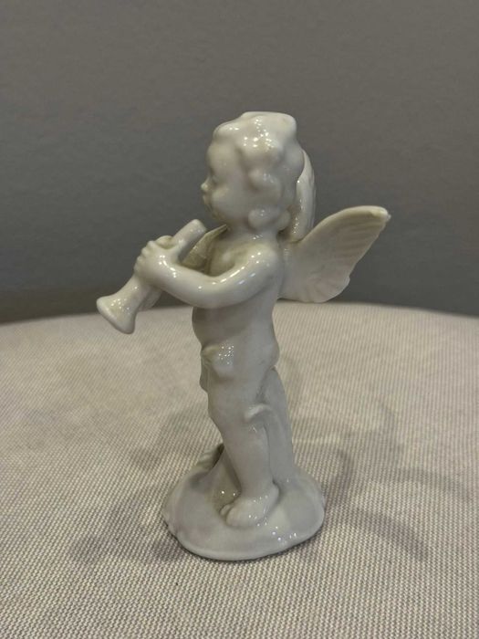 Figurka Putto (aniołek) grający na trąbce, porcelana Wagner & Apel.