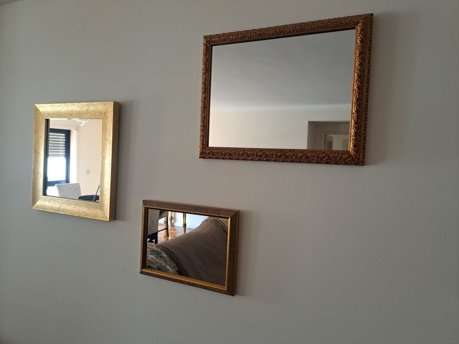 Espelhos com moldura dourada.
