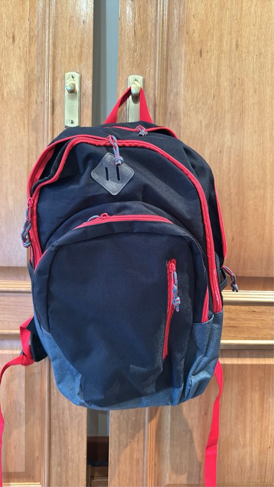 Mochila preta com os fechos em vermelho
