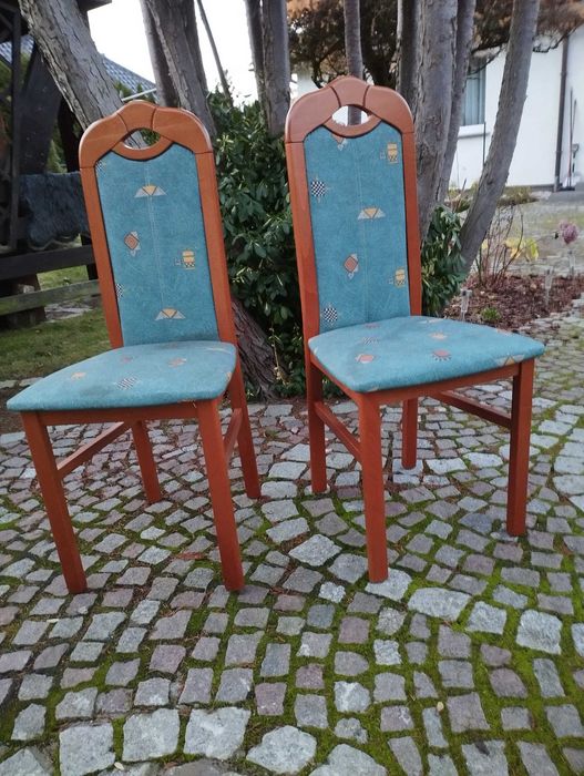 Owalny, rozkładany stół do salonu lub jadalni z krzesłami.