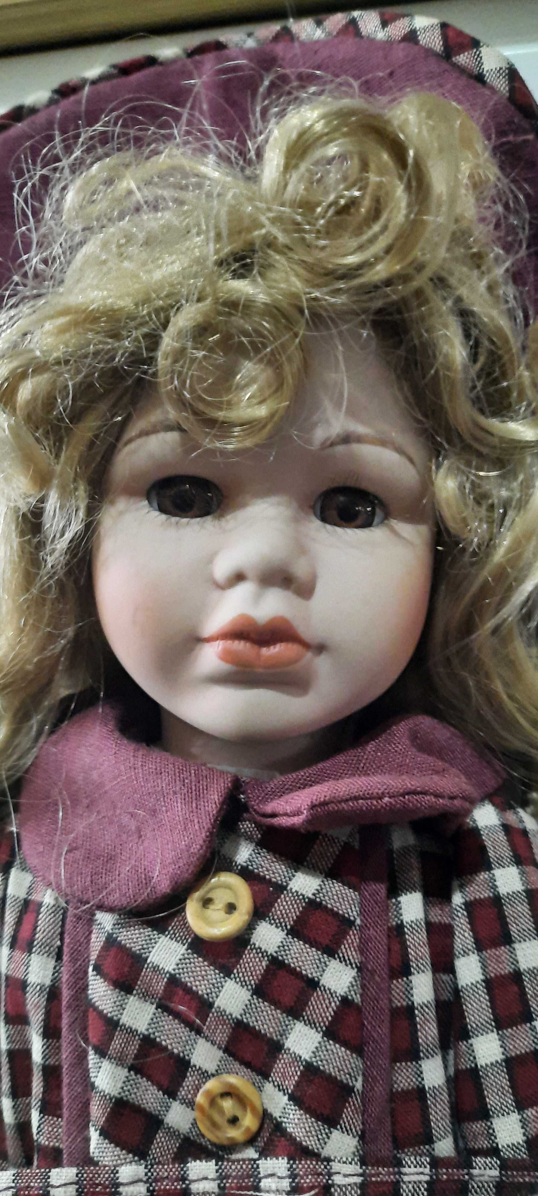 Boneca de porcelana com chapeu, botas e suporte.