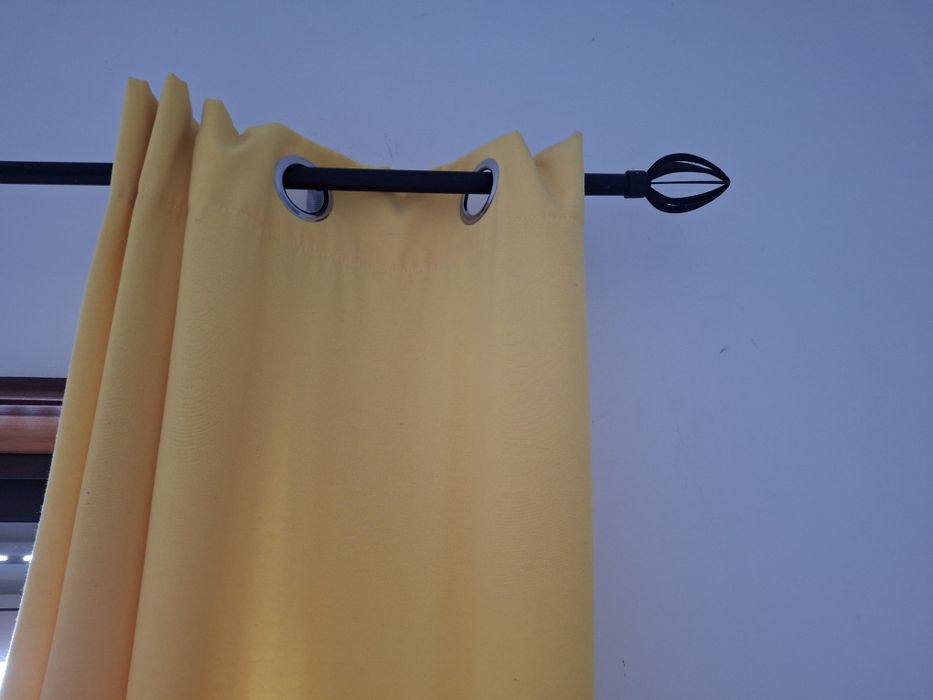 Varão e cortinados amarelos