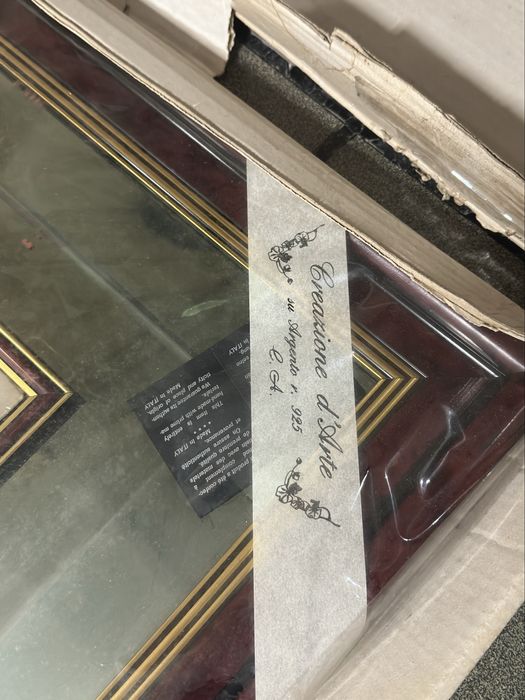 Moldura com espelho e desenhos feitos em prata