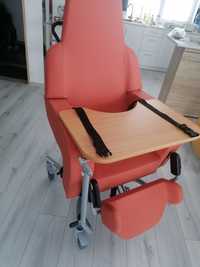 Fotel nie używany dla seniora z podnóżkiem pasami i stolikiem wygodny.