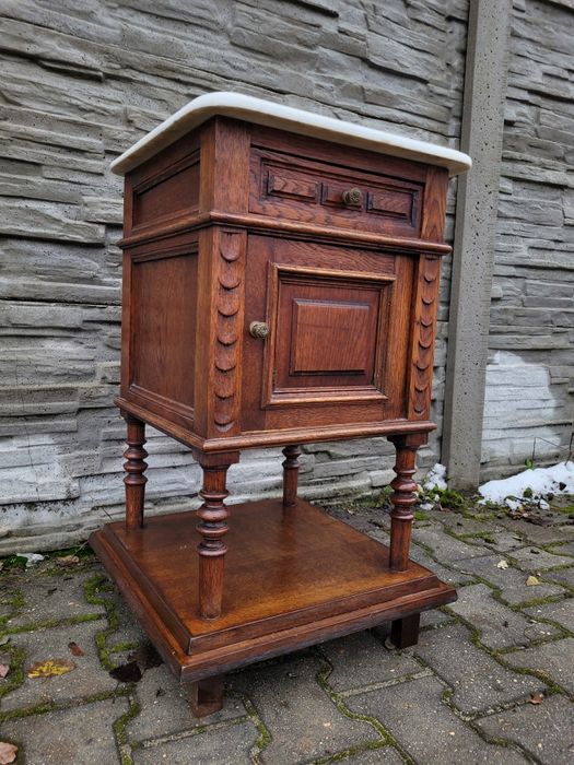 Zgrabna debowa szafka z szufladą.