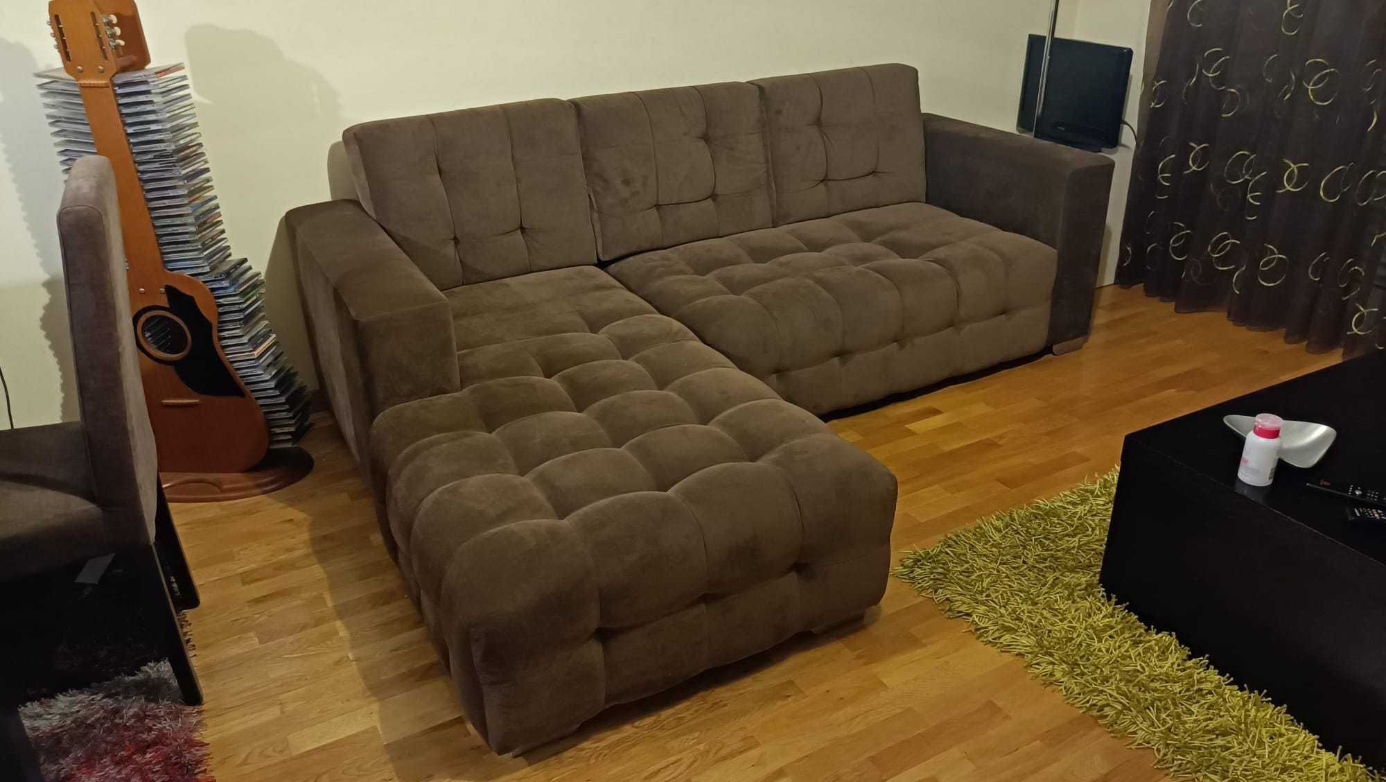 Sofá com chaise long em tecido castanho e com capitonê
