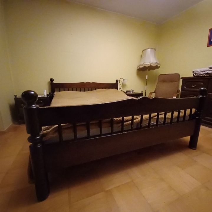 Drewniane łóżko z dwiema szafkami nocnymi
