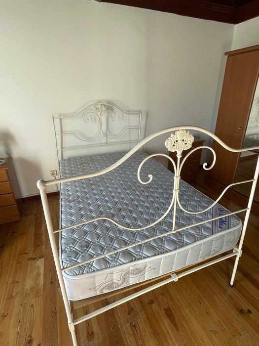 Cama de ferro antiga com colchão e estrado