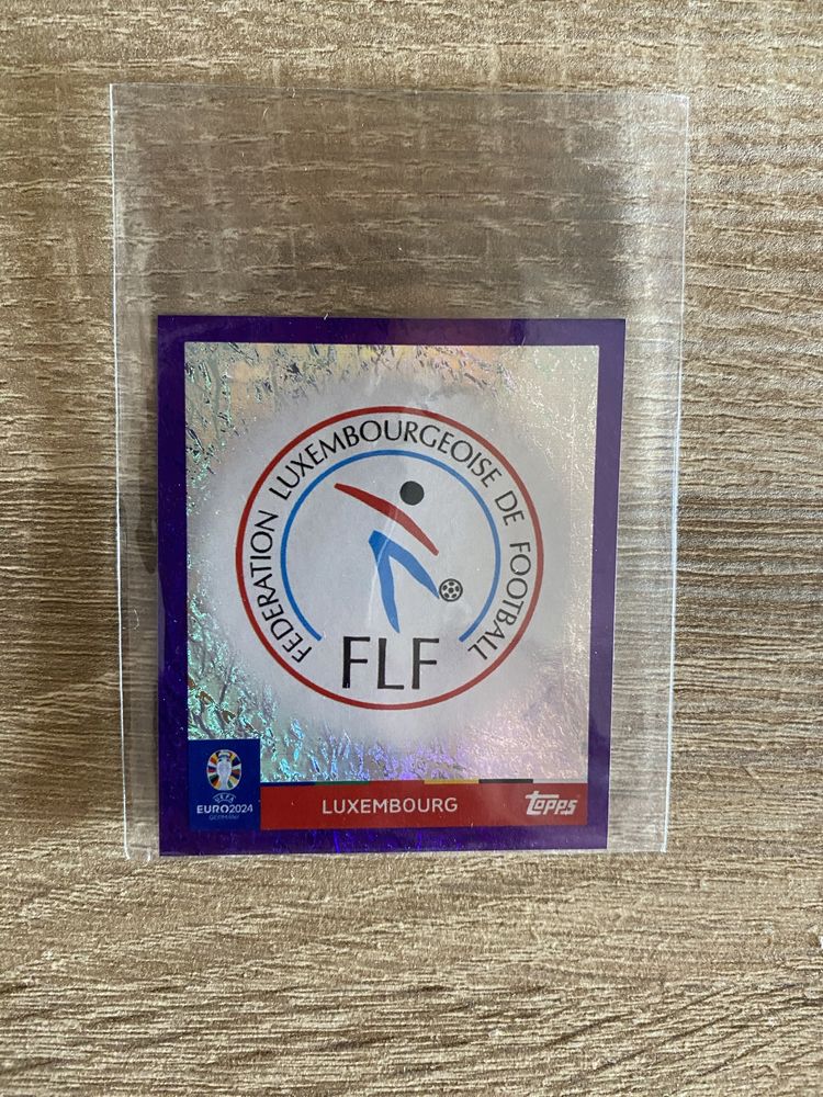 Topps Euro 2024 - Simbolo Luxemburgo Roxo (Raro)