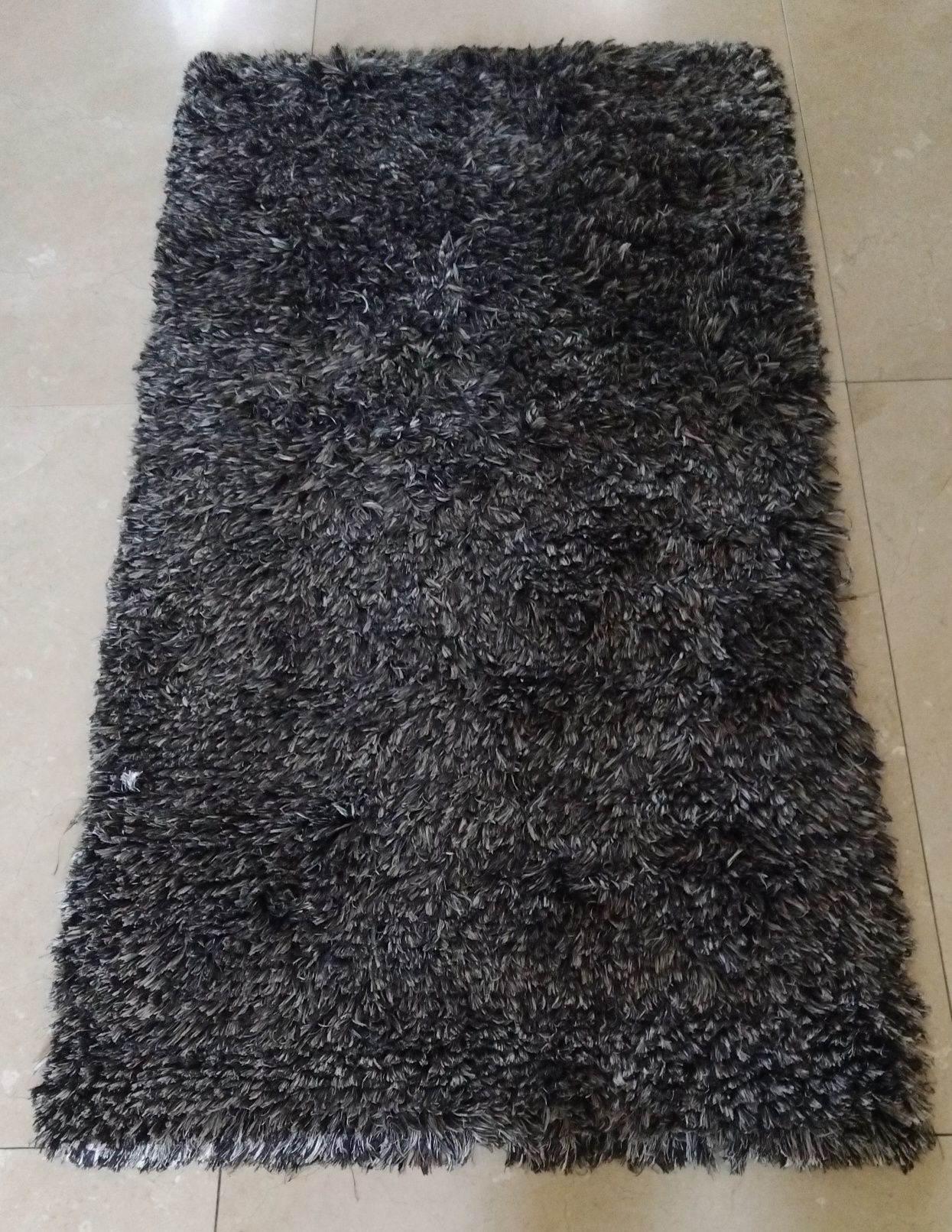 Tapete cinzento com pelos e relevo
