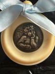 Medalhao de berco em prata e materia nobre.