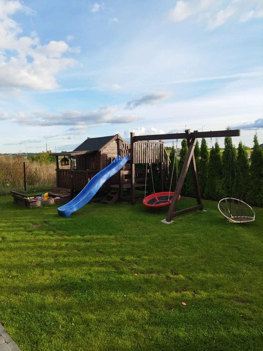 Domek drewniany dla dzieci ze zjeżdżalnia i huśtawkami