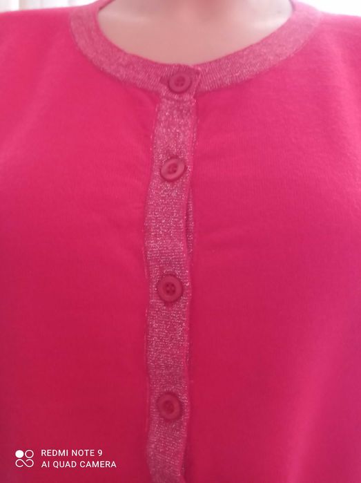 Duży ładny czerwony, damski sweterek z ozdobnym zapięciem.