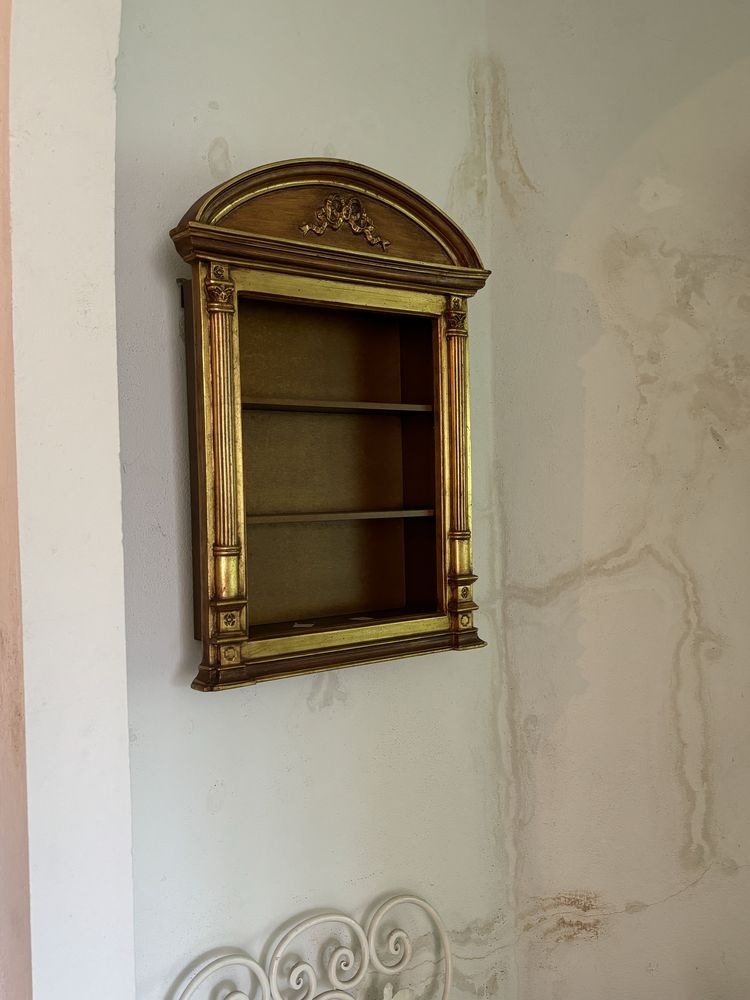 Prateleira e quadro com tela e moldura dourada trabalhada