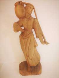 Drewniana rzeźba kobiety z dzbankiem